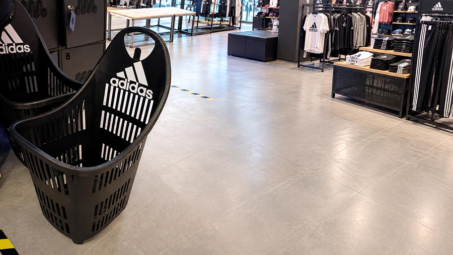 Customer using a rolling basket in a sporting goods store